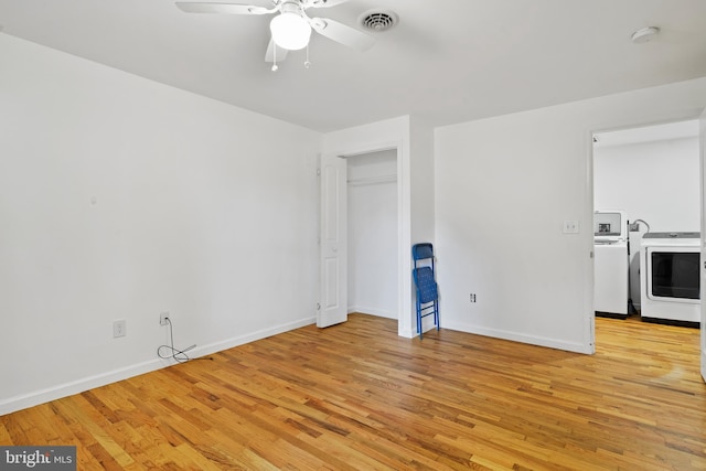 empty room featuring washer / clothes dryer, ceiling fan, and light hardwood / wood-style flooring