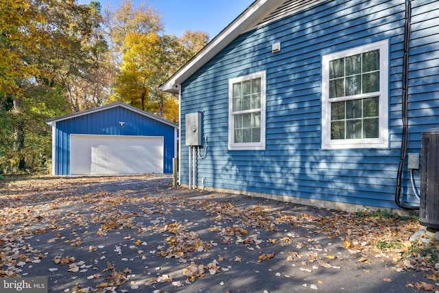 view of property exterior featuring an outbuilding, a garage, and central AC unit