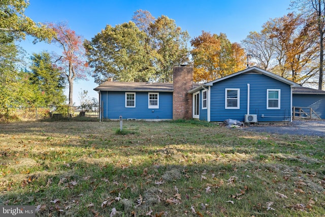 back of house with ac unit and a yard