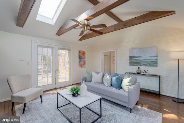 living area featuring french doors, lofted ceiling with beams, brick wall, wood finished floors, and baseboards