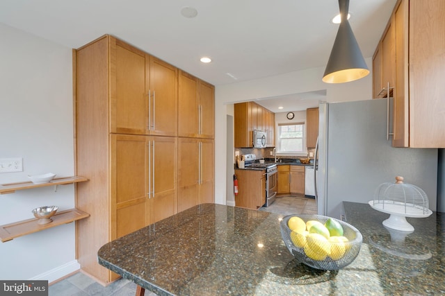 kitchen with tasteful backsplash, dark stone counters, appliances with stainless steel finishes, brown cabinets, and recessed lighting