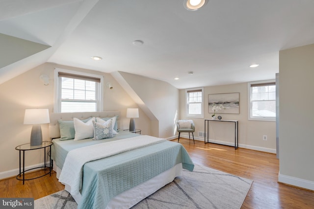 bedroom featuring lofted ceiling, wood finished floors, and baseboards