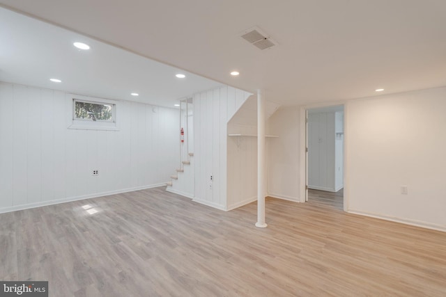 basement featuring stairway, light wood-style flooring, and recessed lighting