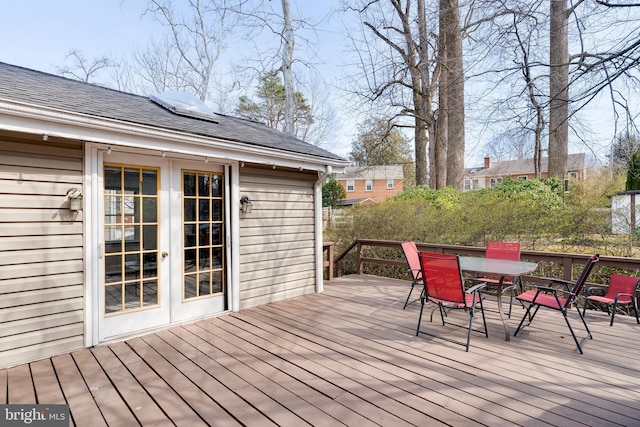 wooden terrace with french doors and outdoor dining space