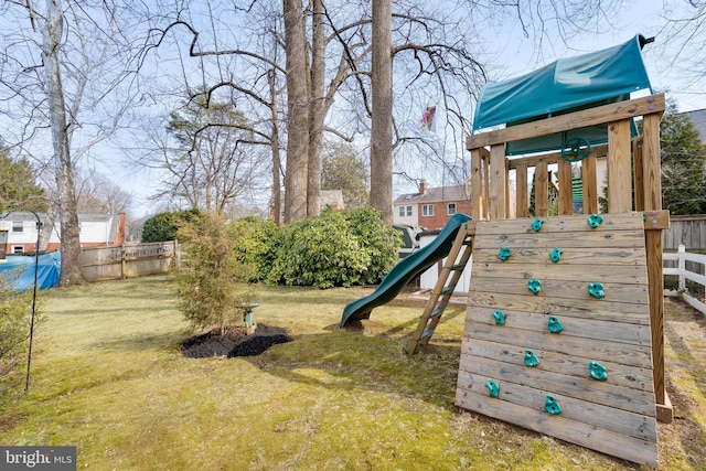 view of jungle gym with fence and a lawn