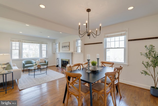 dining area featuring plenty of natural light, a fireplace, recessed lighting, and wood finished floors