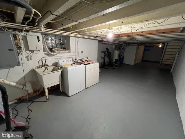 basement featuring sink, electric panel, and separate washer and dryer