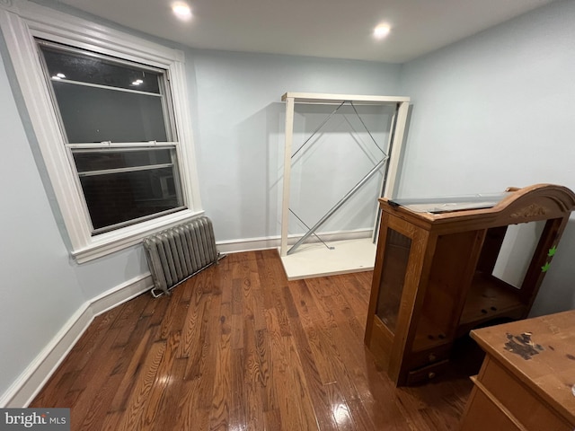 unfurnished bedroom with dark hardwood / wood-style floors and radiator