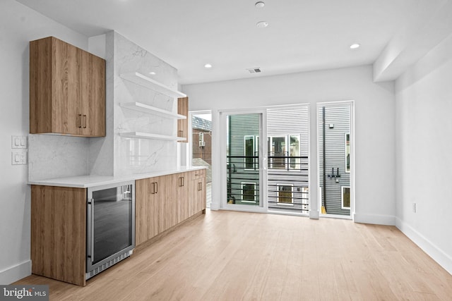 kitchen with light wood finished floors, wine cooler, and open shelves