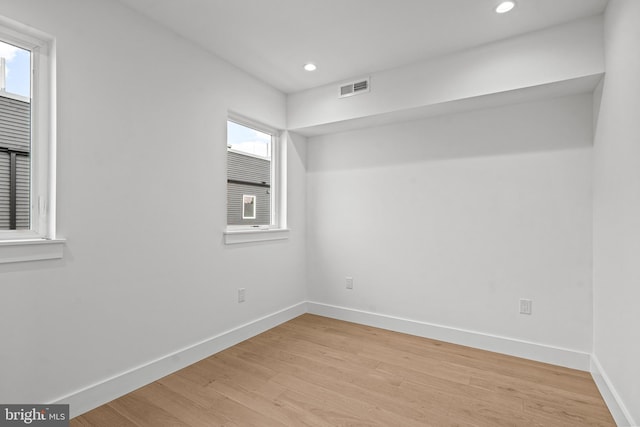 unfurnished room with light wood-type flooring, visible vents, baseboards, and recessed lighting