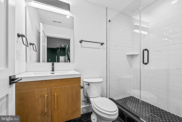 full bathroom with a stall shower, visible vents, vanity, and toilet