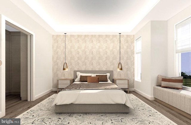 bedroom with wallpapered walls, wood finished floors, an accent wall, and baseboards