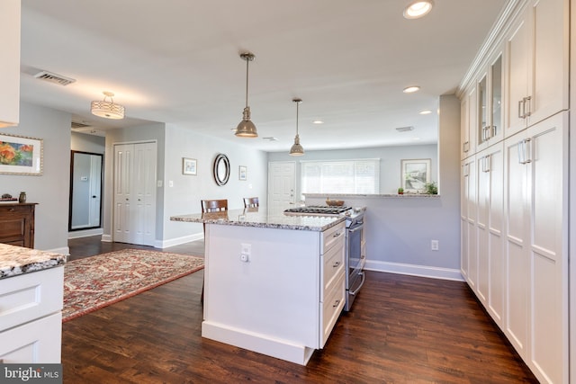 kitchen featuring kitchen peninsula, gas range, white cabinetry, and dark hardwood / wood-style flooring