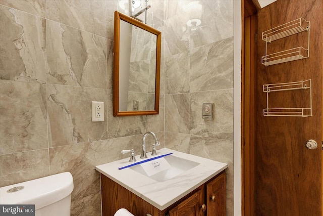 bathroom with vanity, toilet, tile walls, and backsplash