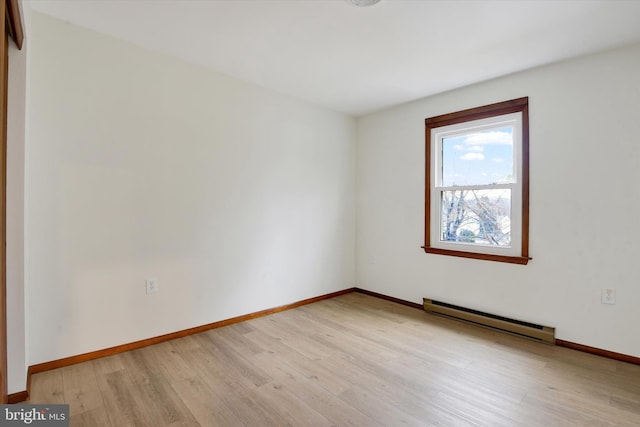 empty room featuring light hardwood / wood-style flooring and a baseboard heating unit