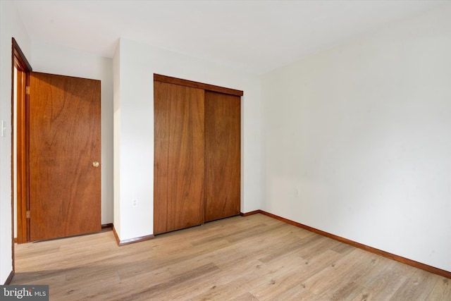 unfurnished bedroom featuring light hardwood / wood-style flooring and a closet