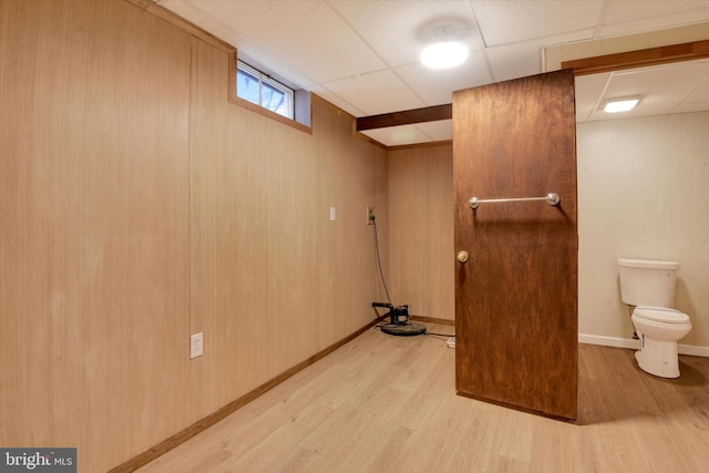 interior space featuring a drop ceiling and light wood-type flooring