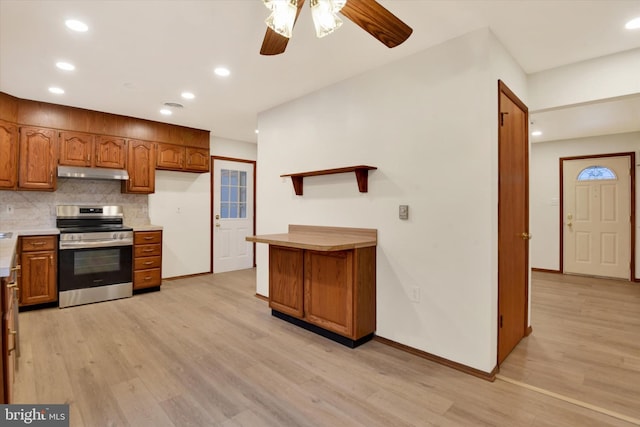 kitchen featuring light hardwood / wood-style flooring, backsplash, ceiling fan, and electric stove