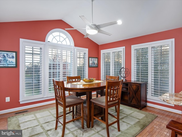 dining area featuring lofted ceiling, hardwood / wood-style floors, ceiling fan, and plenty of natural light