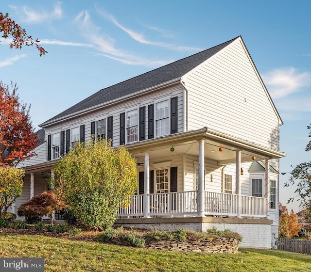 farmhouse with a front lawn, covered porch, and ceiling fan