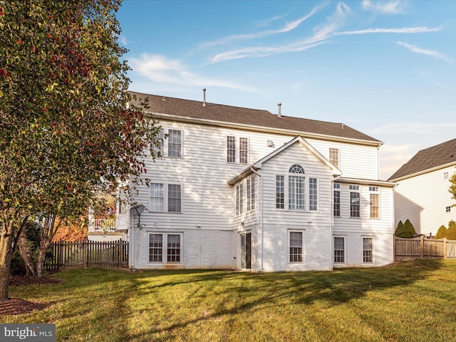 rear view of property with a lawn