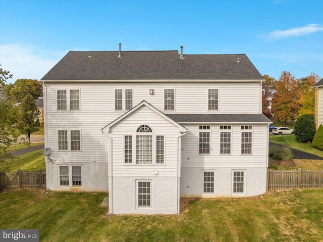 rear view of house featuring a yard