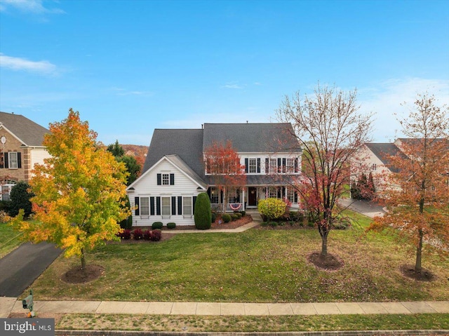 colonial home with a porch and a front lawn