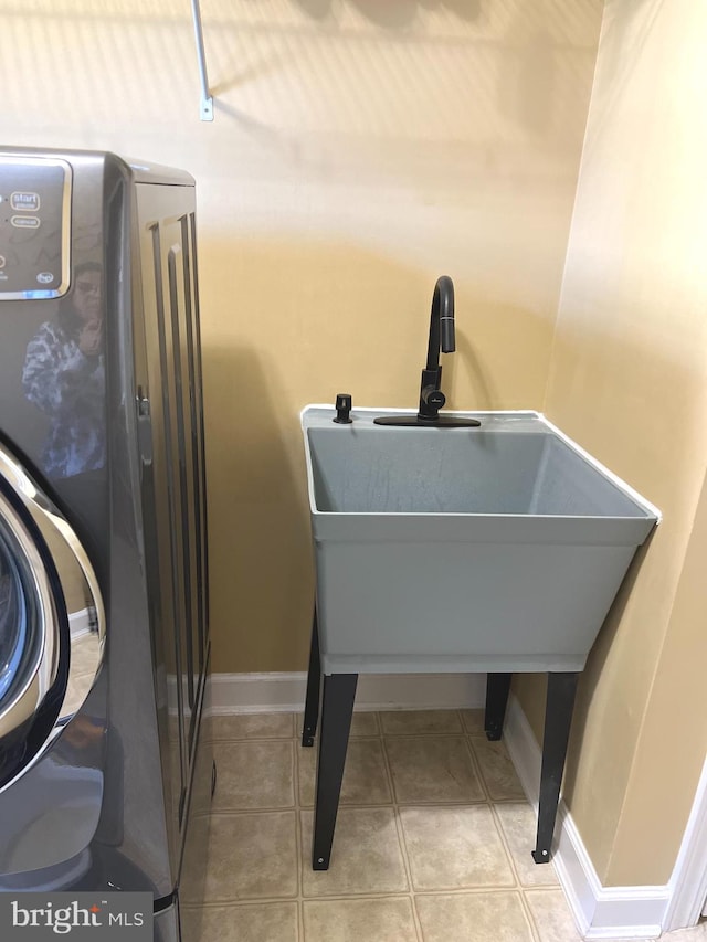 interior space featuring washer / dryer, light tile patterned floors, and sink