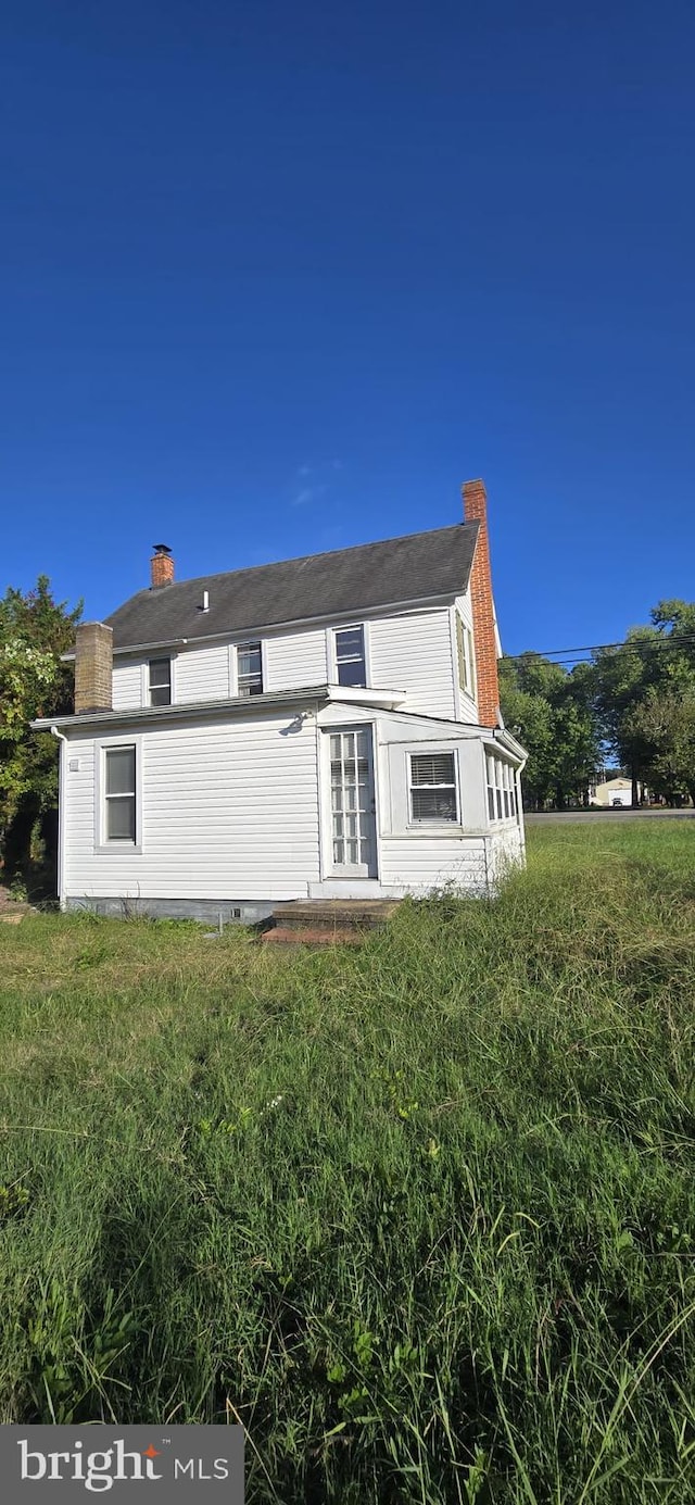 back of property featuring a yard