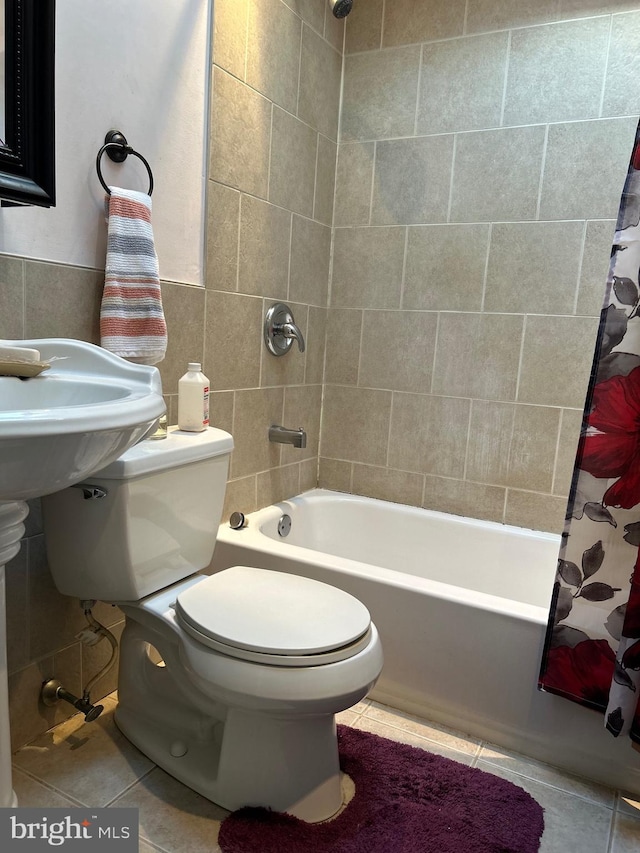 bathroom featuring toilet, tile patterned floors, tile walls, and shower / bath combo