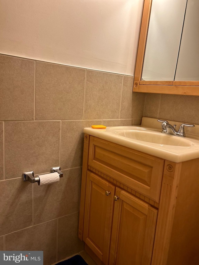 bathroom featuring vanity and tile walls