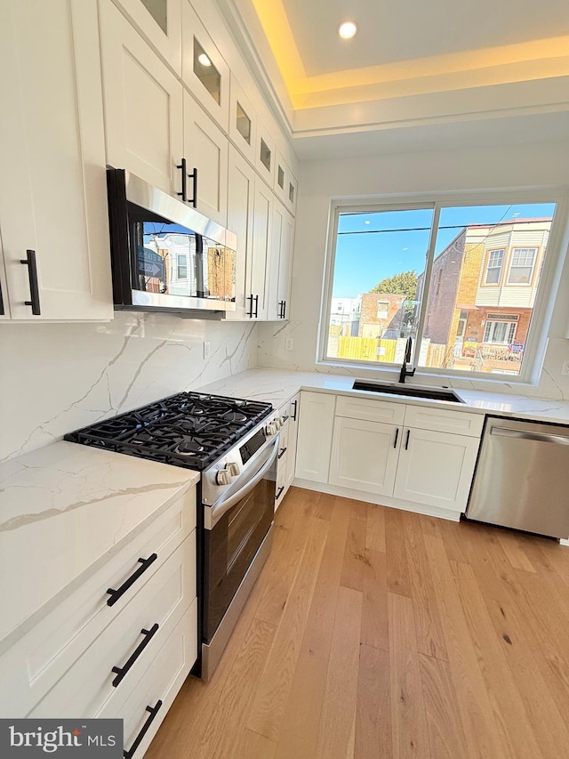 3011 Gaul St, Philadelphia, PA 19134 - kitchen with stainless steel appliances, a sink, light wood-type flooring, white cabinets, and recessed lighting