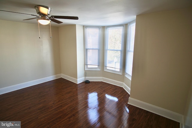 spare room featuring dark hardwood / wood-style floors and ceiling fan