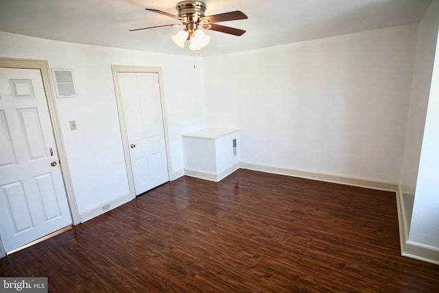 spare room with dark wood-type flooring and ceiling fan