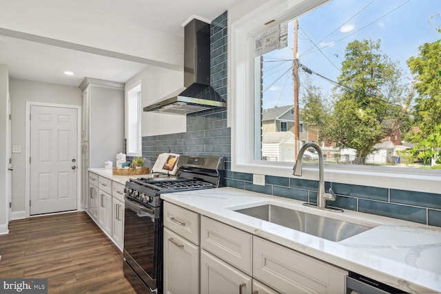 kitchen with wall chimney exhaust hood, dark wood-type flooring, backsplash, sink, and appliances with stainless steel finishes