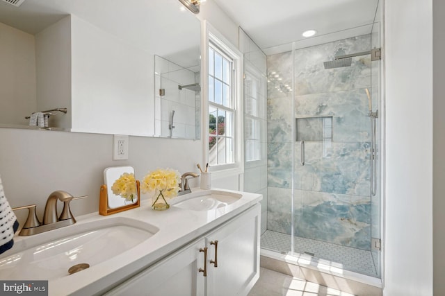 bathroom with vanity, a healthy amount of sunlight, a shower with shower door, and tile patterned floors