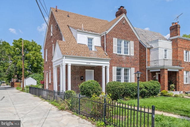 view of front of home with a front lawn and a balcony