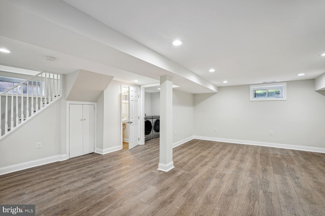 basement with light hardwood / wood-style floors and separate washer and dryer