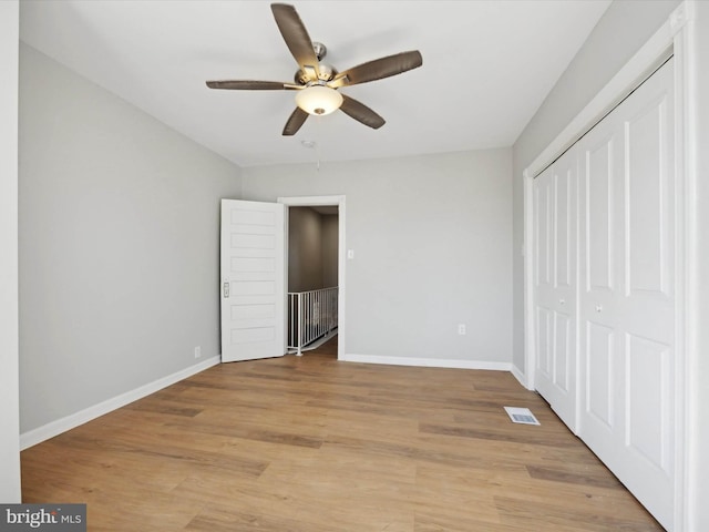 unfurnished bedroom with light hardwood / wood-style flooring, ceiling fan, and a closet