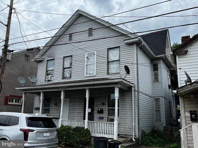 view of front property featuring a porch and cooling unit