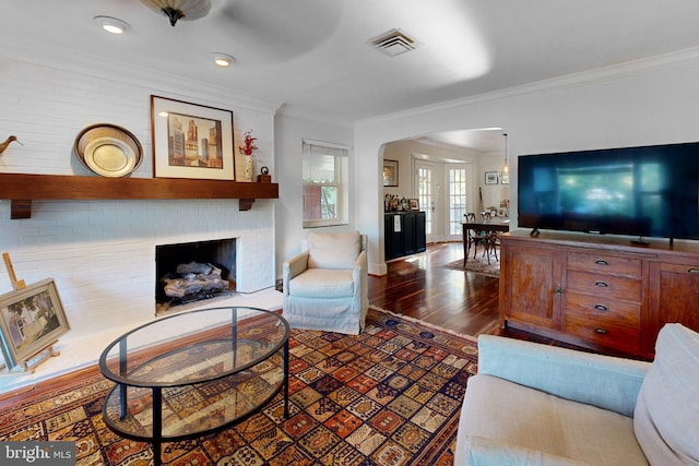 living room with crown molding, dark hardwood / wood-style floors, and a fireplace