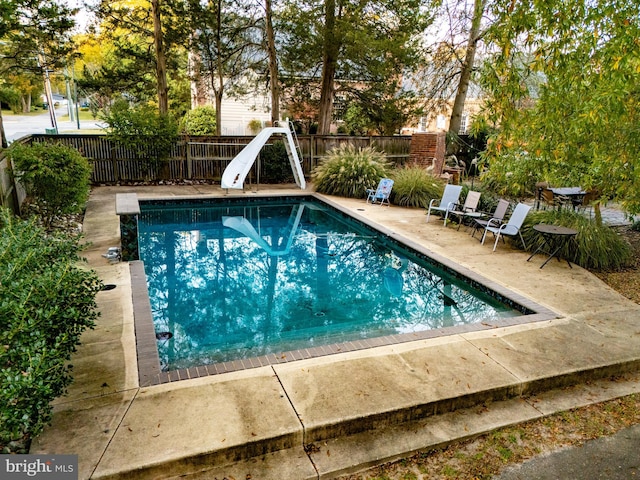 view of pool featuring a patio and a water slide