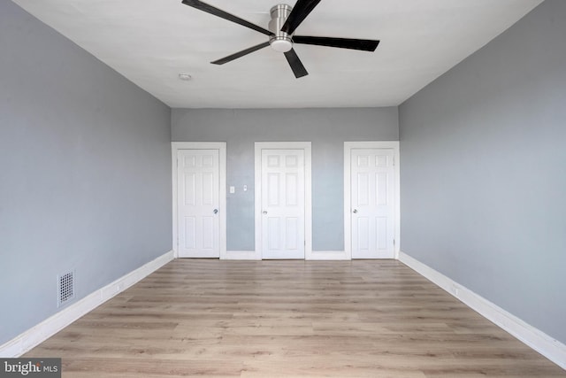 unfurnished bedroom with ceiling fan, two closets, and light hardwood / wood-style floors