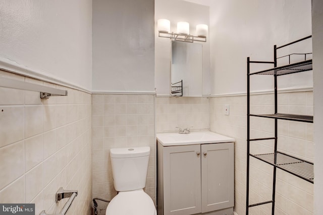 bathroom with tile walls, vanity, and toilet