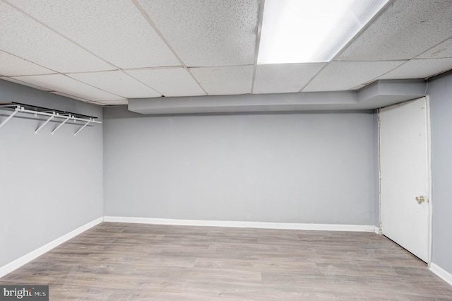 interior space featuring a drop ceiling and light hardwood / wood-style flooring