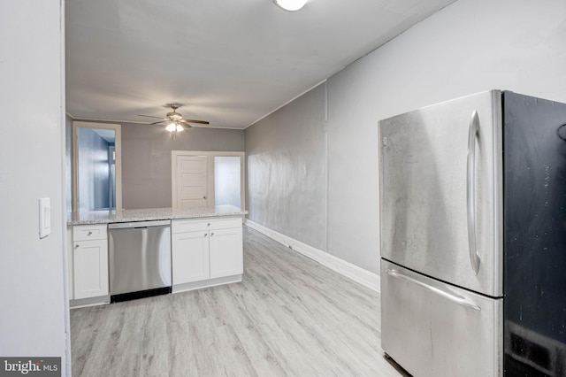 kitchen featuring light stone countertops, white cabinetry, light hardwood / wood-style floors, stainless steel appliances, and ceiling fan