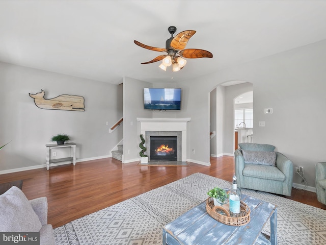 living room featuring hardwood / wood-style flooring, a fireplace, and ceiling fan