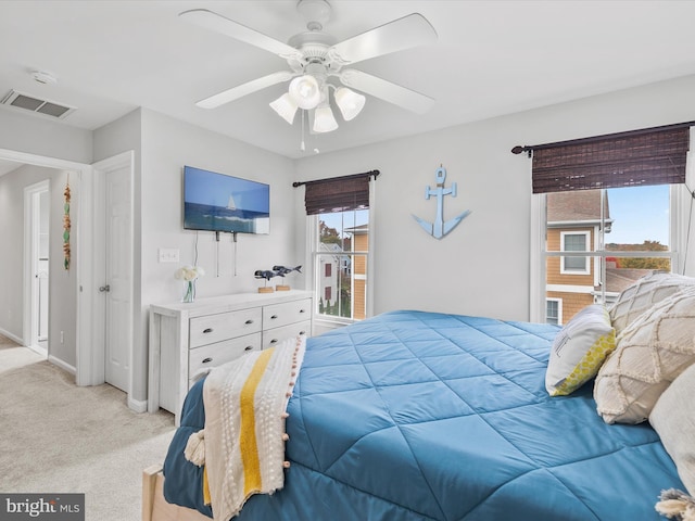 carpeted bedroom with ceiling fan and multiple windows