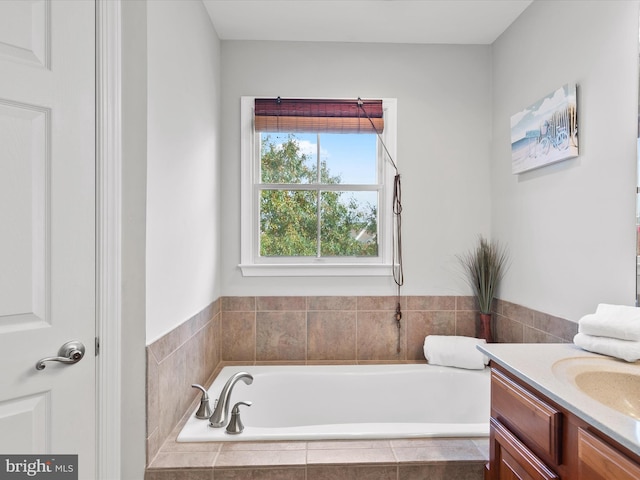 bathroom featuring vanity and a relaxing tiled tub