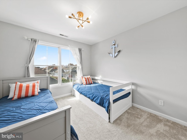 bedroom with an inviting chandelier and light colored carpet